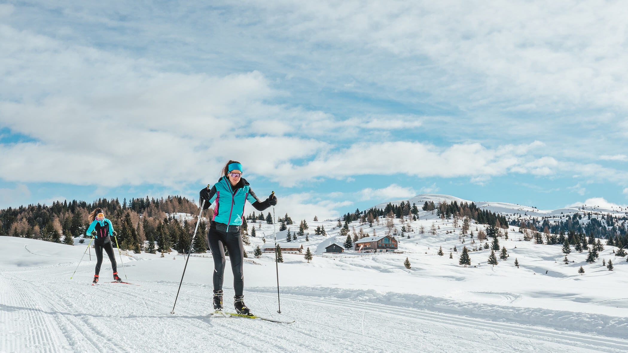 Zwei Frauen beim Langlaufen auf der Loipe inmitten einer Winterlandschaft - Oberplunerhof
