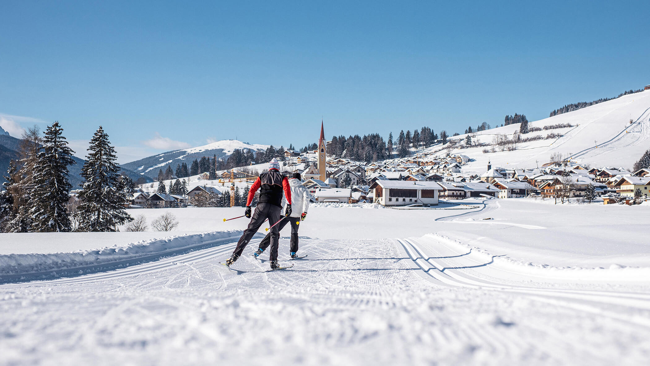 Zwei Langläufer auf der Loipe vor dem Dorf Kiens - Oberplunerhof