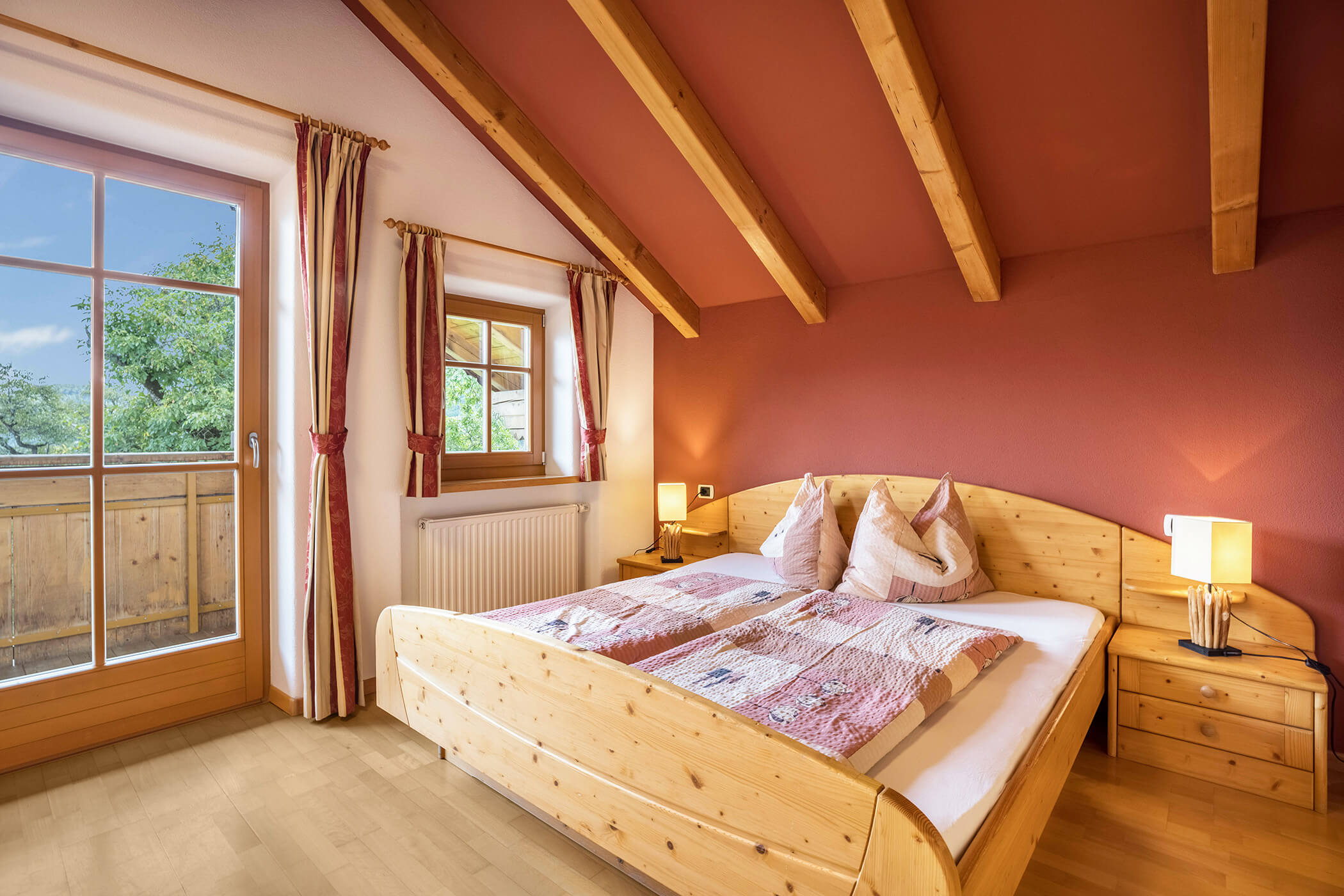 Double bed in the Plan de Corones apartment with view of the balcony - Oberplunerhof