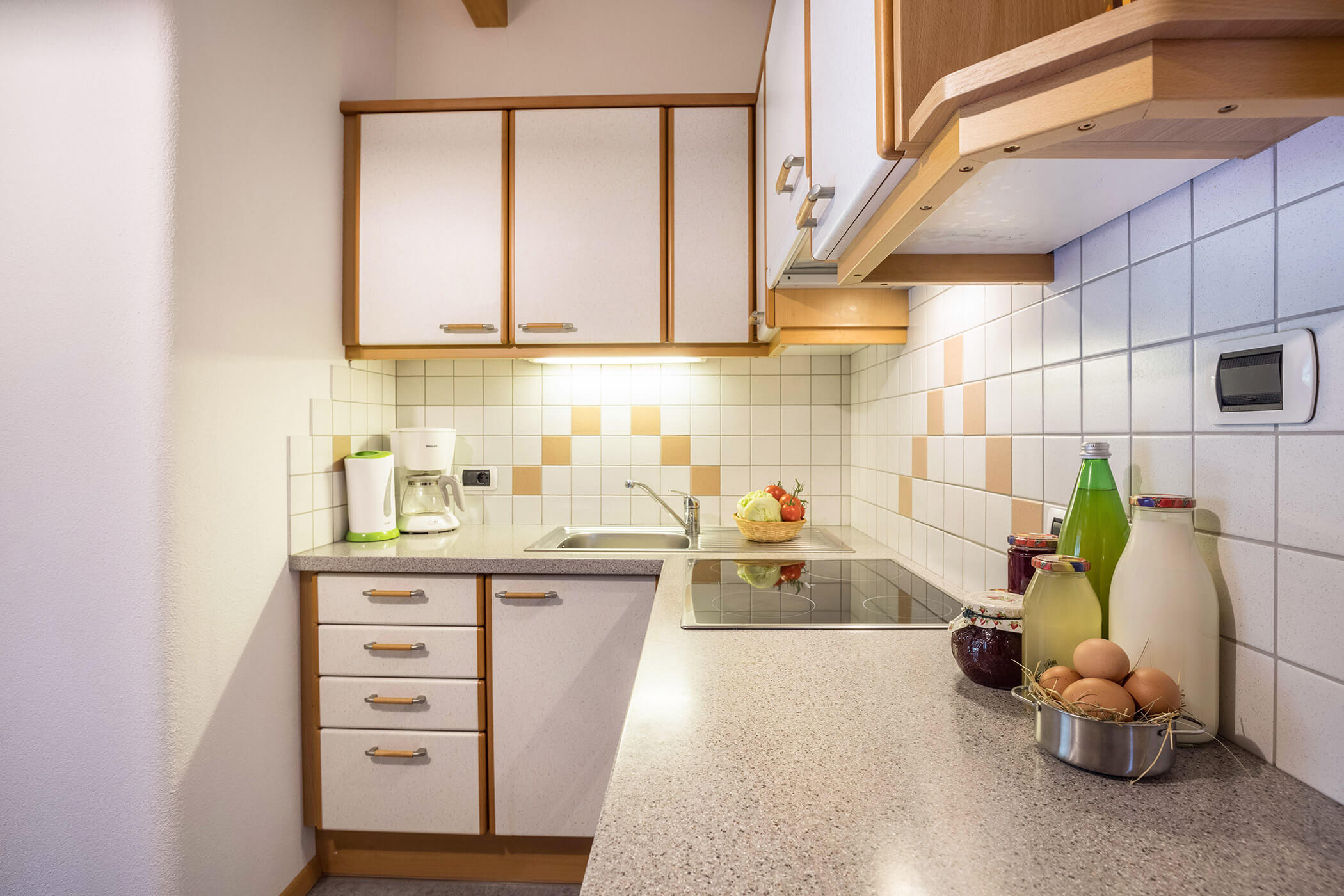 Kitchen in the Plan de Corones apartment with farm produce such as milk, juices, jam and eggs - Oberplunerhof