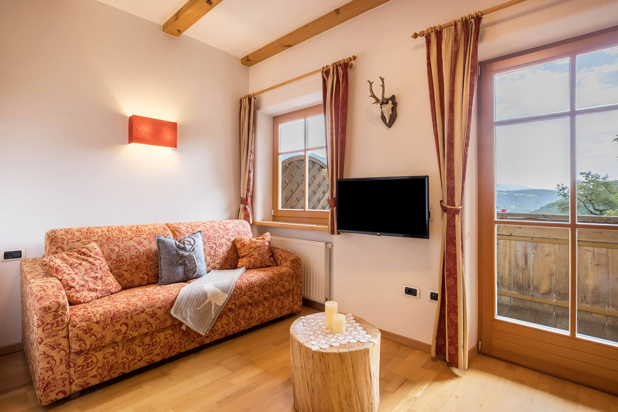 Living room in the Plan de Corones apartment with sofa, TV and small round table - Oberplunerhof