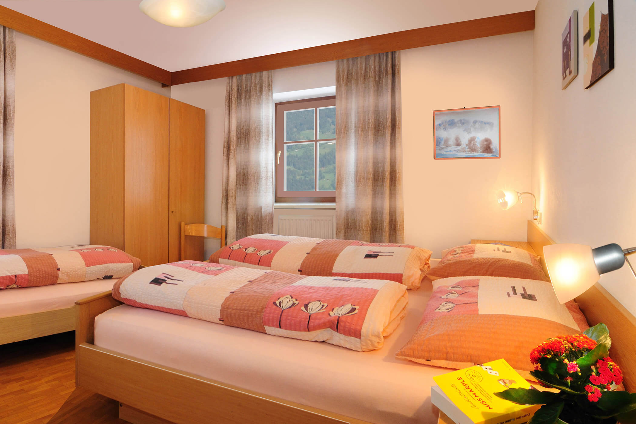 Bedroom in the Panorama apartment at the Radmüllerhof with double bed, single bed and wooden wardrobe - Oberplunerhof