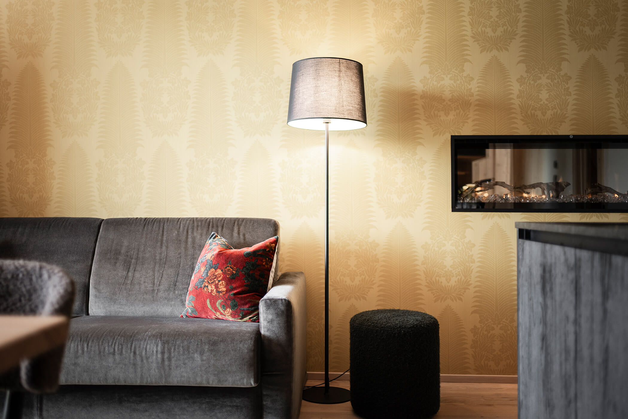 Gray sofa with a floor lamp and yellow wall - Oberplunerhof