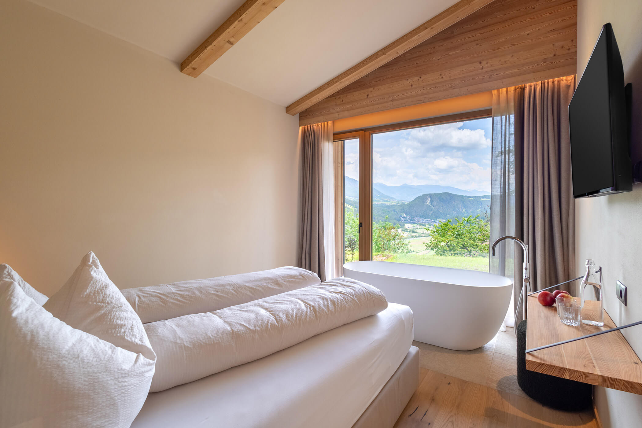 Bedroom in Chalet Woods with double bed, free-standing bathtub and views of the valley and mountains - Oberplunerhof