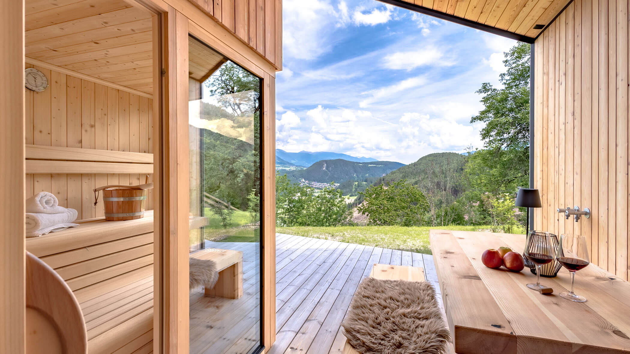 Sauna in Chalet Woods with a view of the mountains, next to a table with two glasses of wine - Oberplunerhof