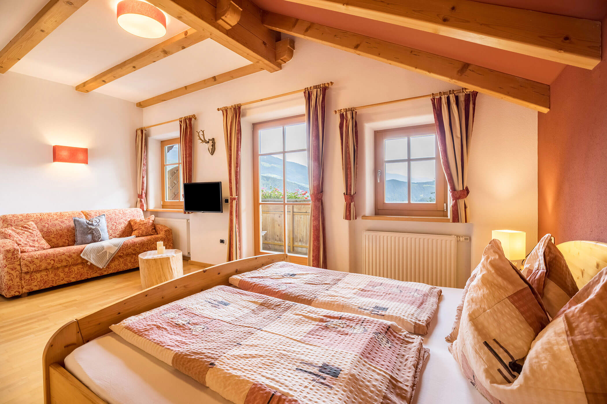 Bedroom in the Plan de Corones apartment with double bed and sofa - Oberplunerhof