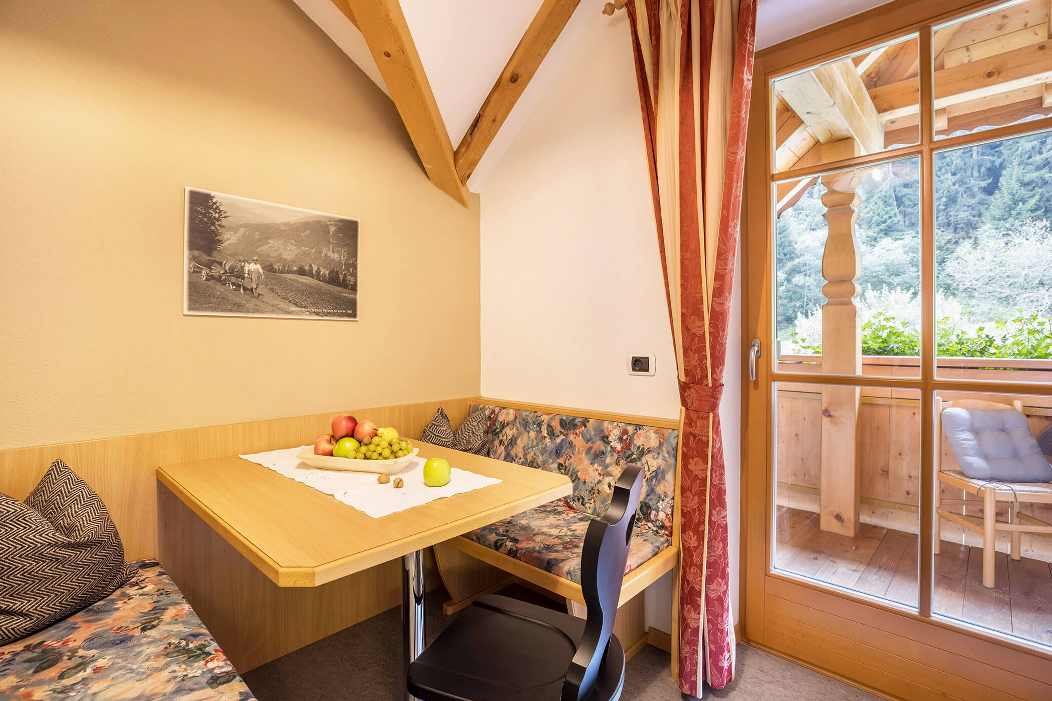 Dining table with two benches and view of the balcony in Apartment Plan de Corones - Oberplunerhof