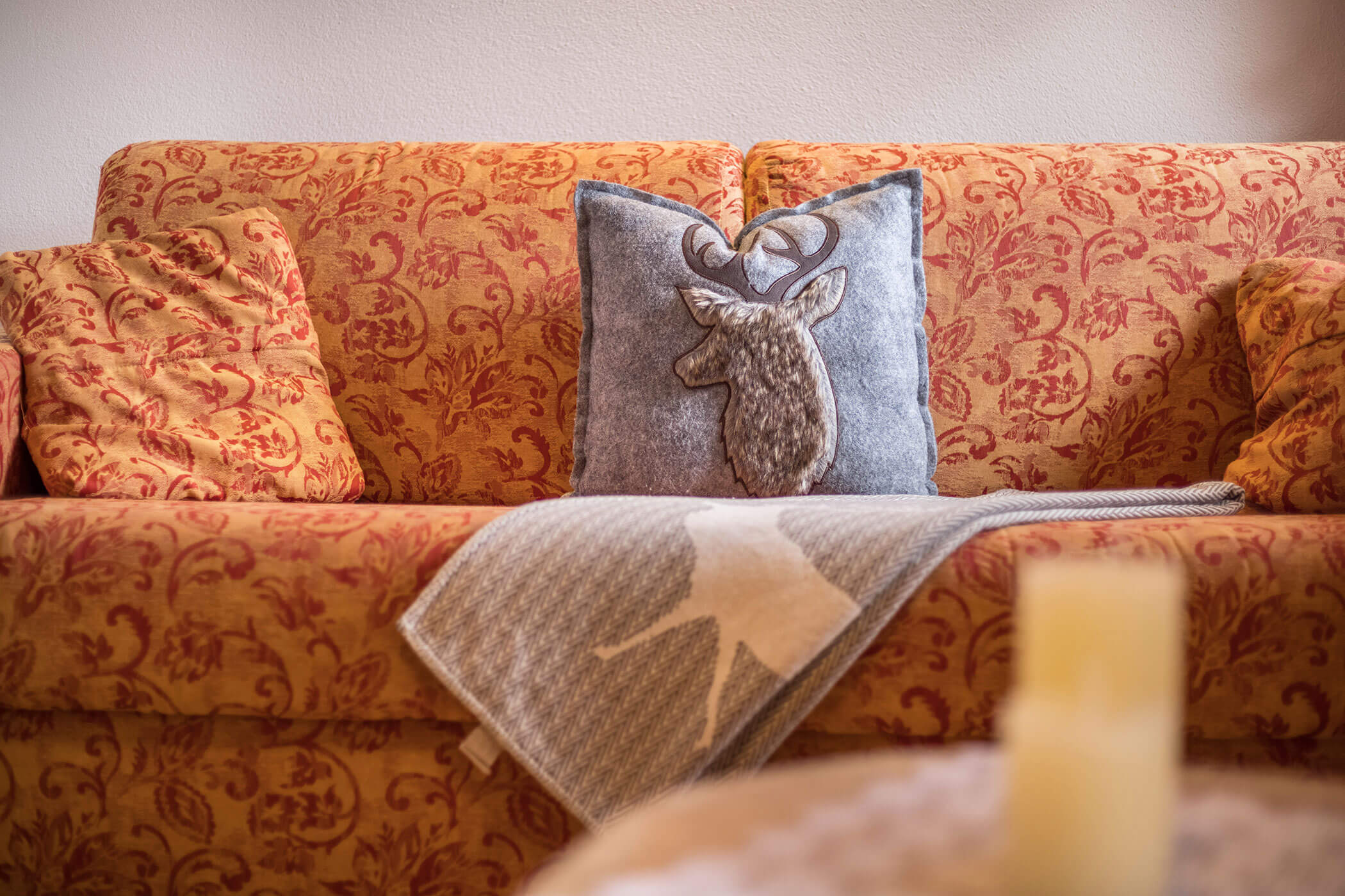 Sofa in the bedroom of the Plan de Corones apartment with three pillows and a blanket - Oberplunerhof
