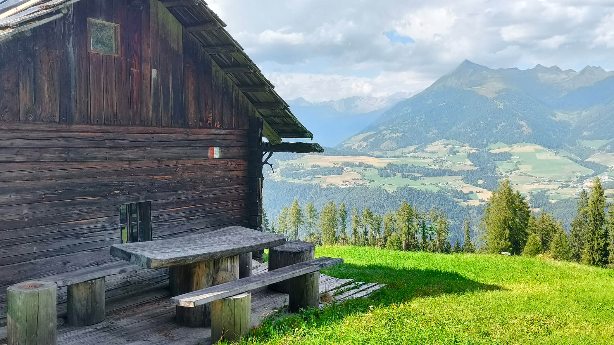 Malga con tavolo e panche in legno con una fantastica vista sulle montagne dell'Alto Adige - Oberplunerhof