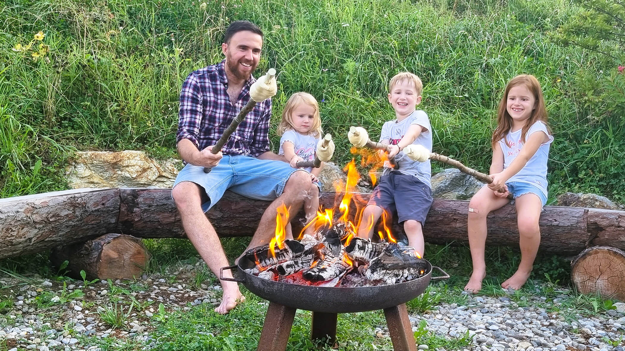 Padre con i suoi tre figli prepara il pane su un bastone davanti al camino - Oberplunerhof