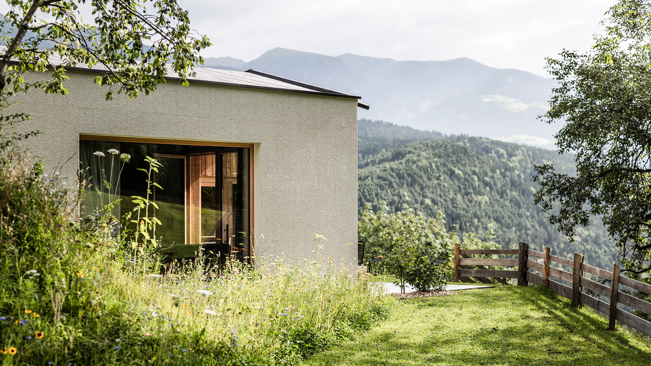 A green meadow with flowers in front of the chalets - Oberplunerhof