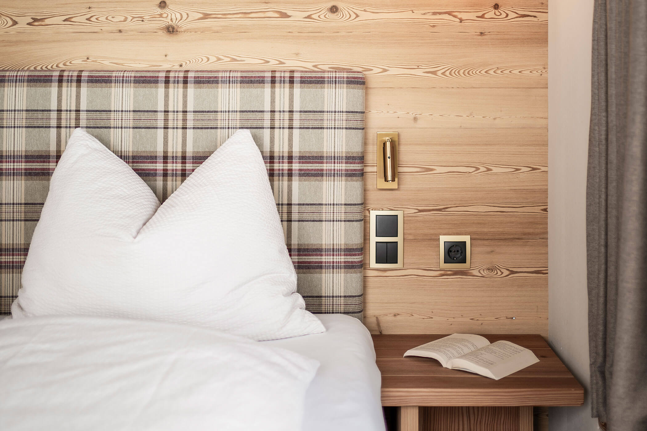 Bedroom in Chalet Skyline with bedside table and a book - Oberplunerhof
