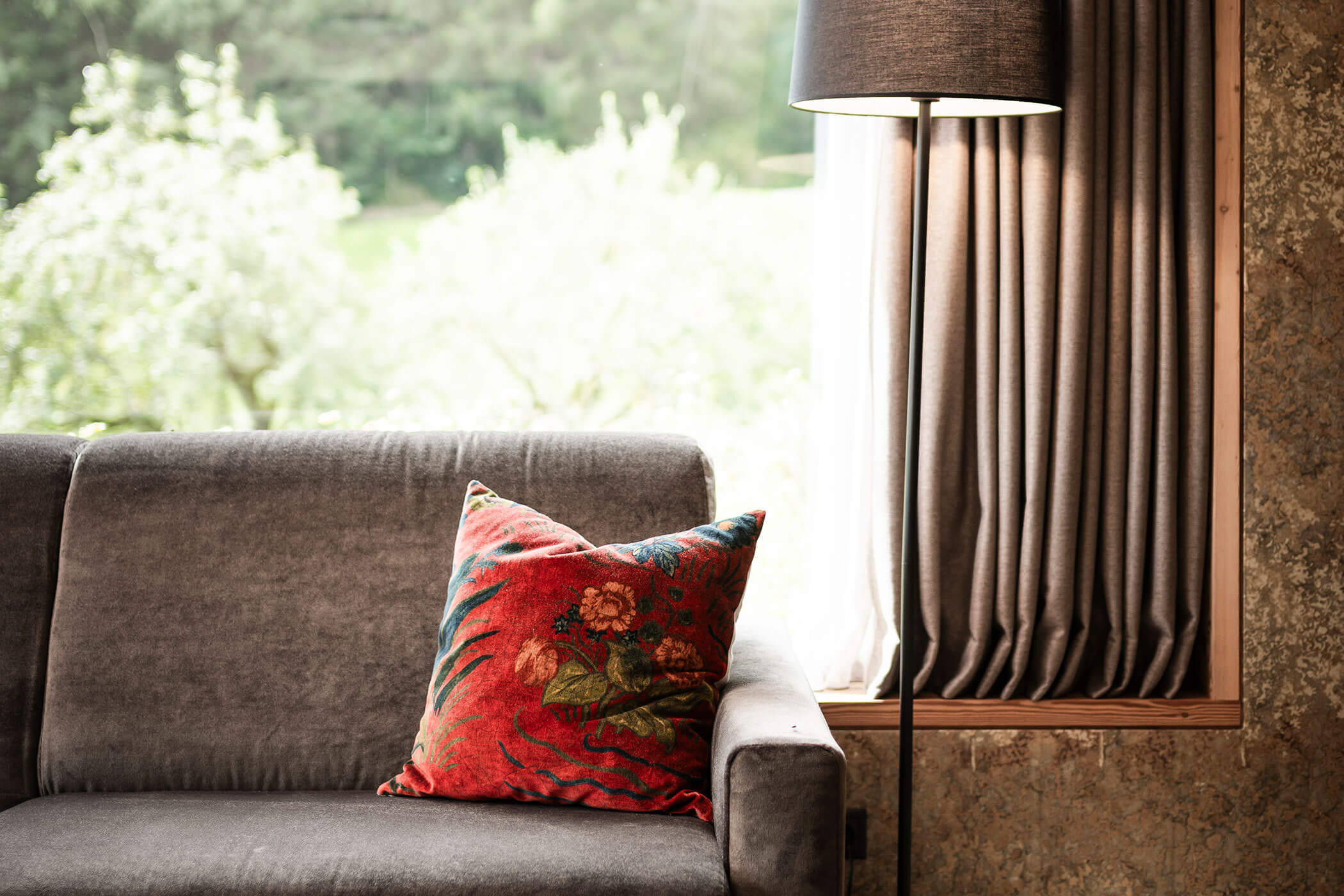 Sofa with red cushion in Chalet Woods - Oberplunerhof